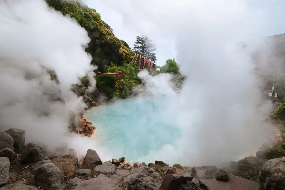 Steam rising from a blue hot-spring pond in Beppu